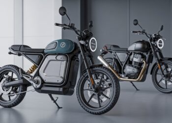 A close-up of an electric motorbike’s battery and a petrol bike’s fuel tank under bright showroom lights.