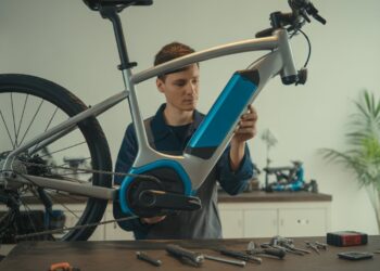 A focused mechanic repairing an electric bike’s motor in a clean workshop.