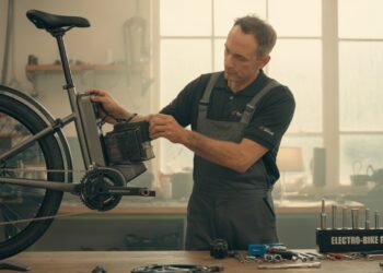 Mechanic repairing an e-bike motor and battery in a workshop